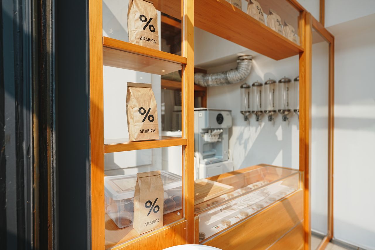 Home Showcasing premium Arabica coffee bags in a sleek, sunlit retail setting.