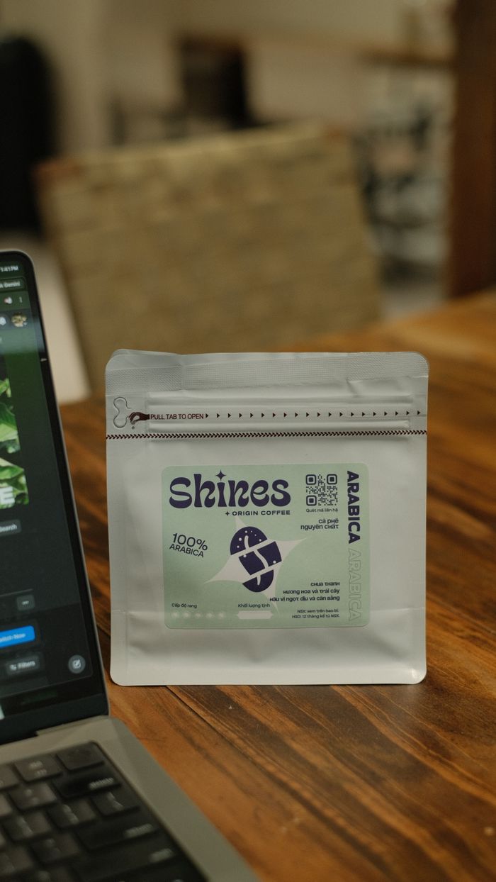 Services Close-up of Shines Arabica coffee packaging with laptop background.